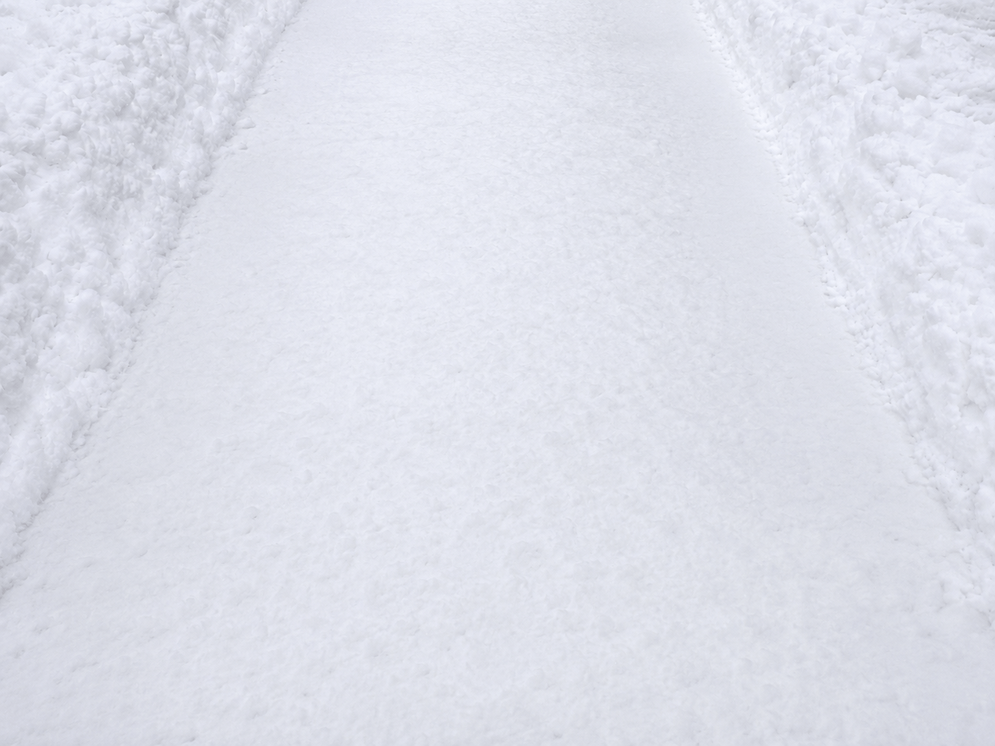 Verschneiter Gehweg vor dem Winterdienst